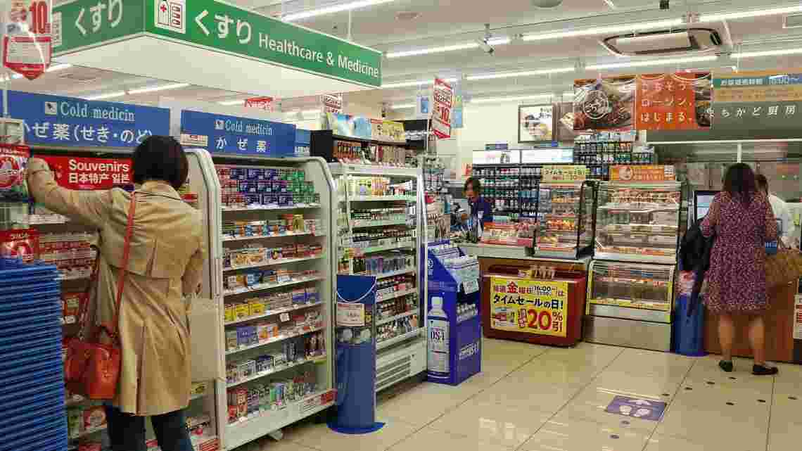 コンビニの医薬品コーナーで薬を見ている客