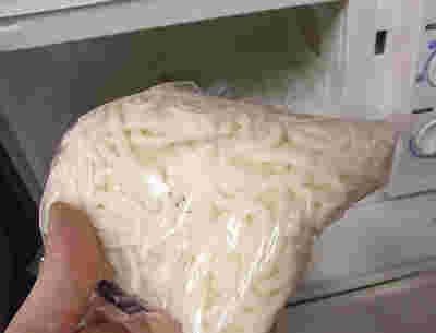 ゆでうどんを袋ごと電子レンジへ入れる様子