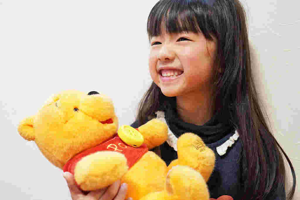 プーさんのぬいぐるみと子供の画像