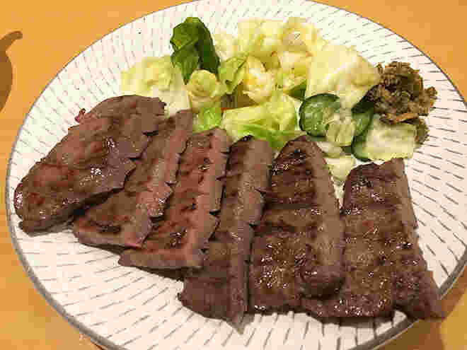 皿に盛られた牛タンステーキとキャベツの浅漬け