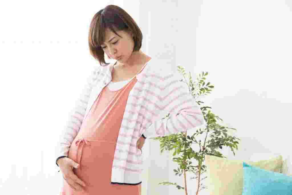 お腹に手を当てている妊婦