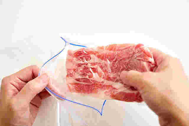 賞味期限が切れていない冷凍肉をフリーザバッグに入れている画像