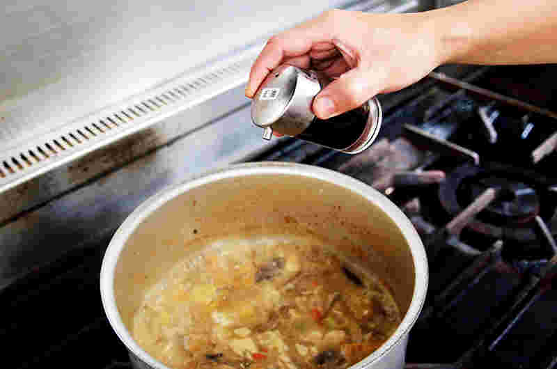 豚汁に隠し味となる調味料を加えているところ