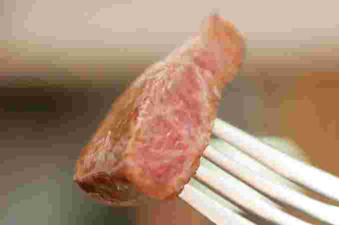 レアステーキをフォークにさしている様子