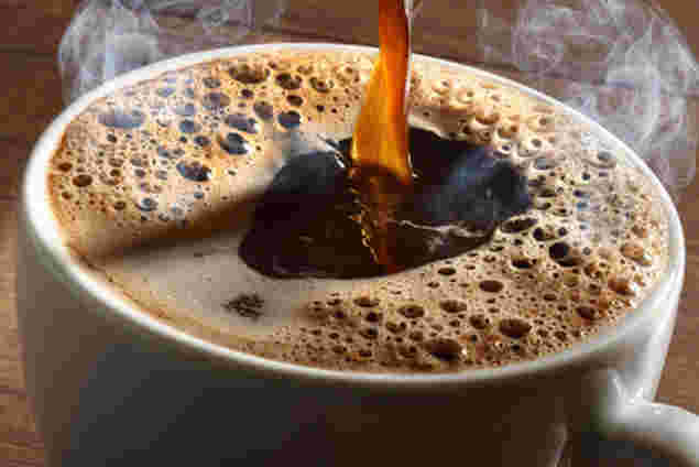 コーヒーをカップいっぱいに注ぎ入れる様子
