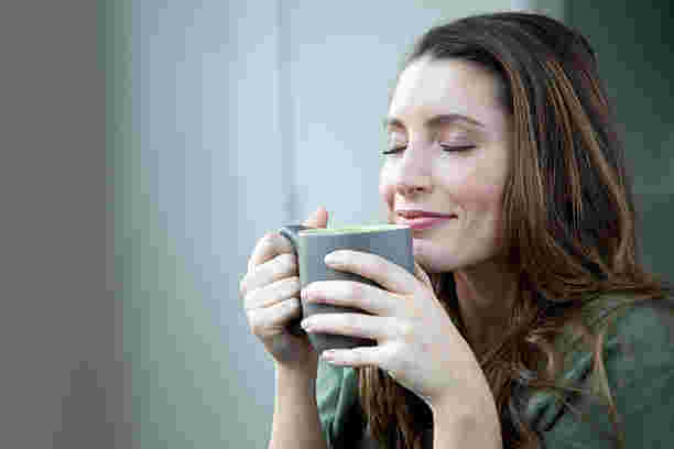 笑顔でコーヒーを飲む女性