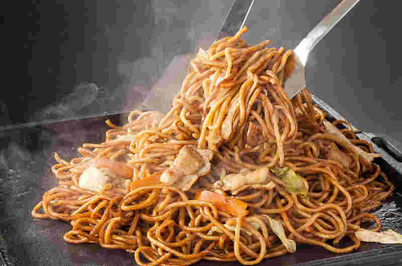 焼きそばを大きな鉄板で炒めている
