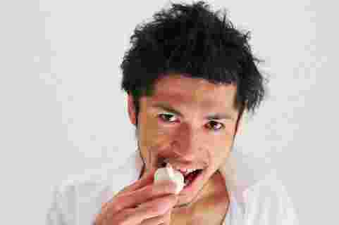 生のにんにくを食べている人