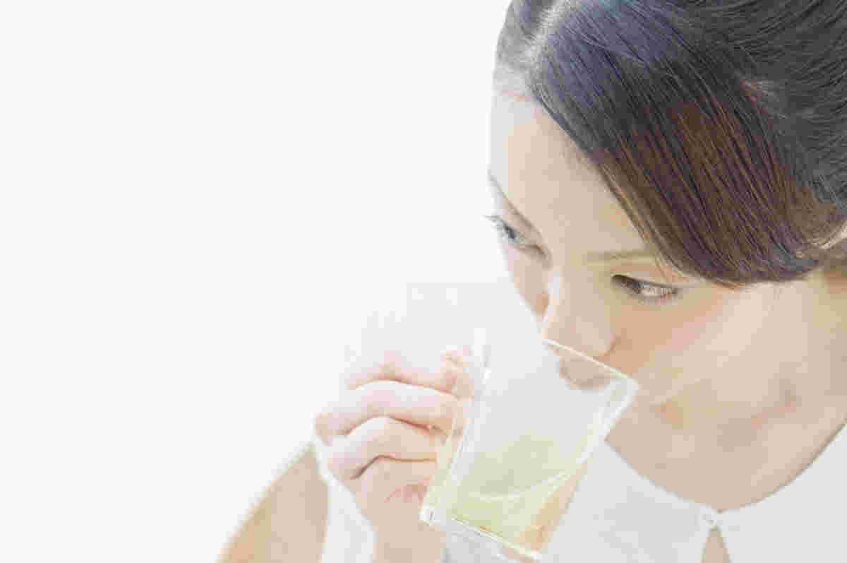 ダイエット中にコップで水を飲む女性