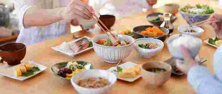 家族で白米とおかずのご飯を食べている様子