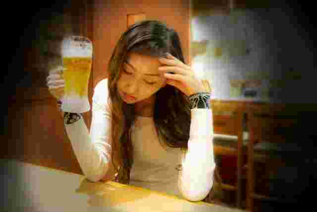 体調が悪くビールをまずいと感じる女性