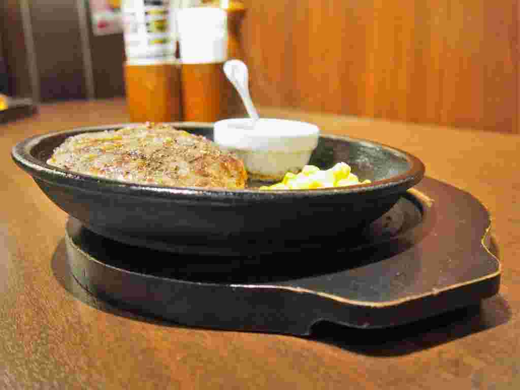 鉄板を傾けて油切りしているいきなりステーキのワイルドハンバーグ