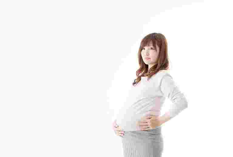 妊婦が大きいお腹を支えている