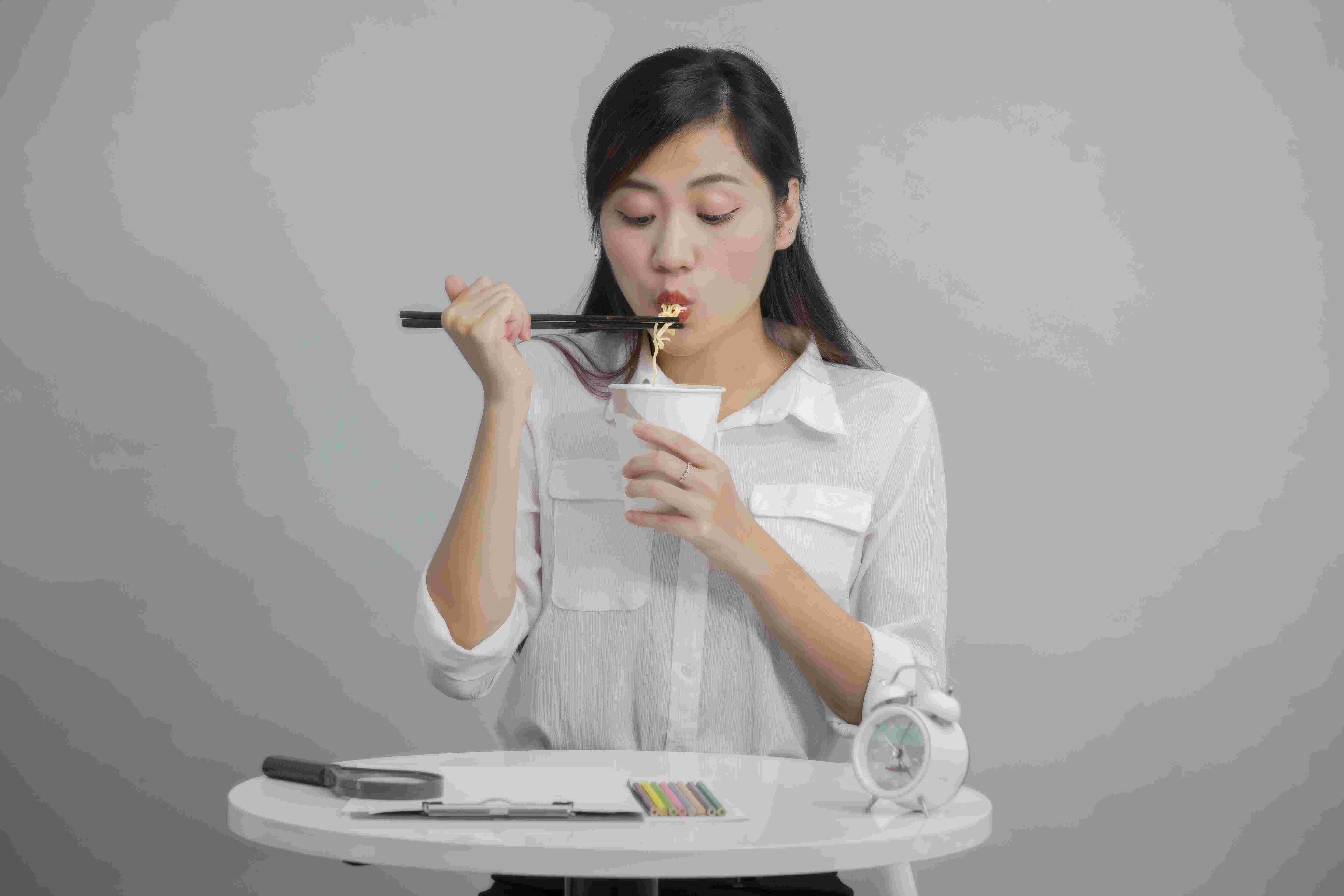 カップラーメンを食べる女性