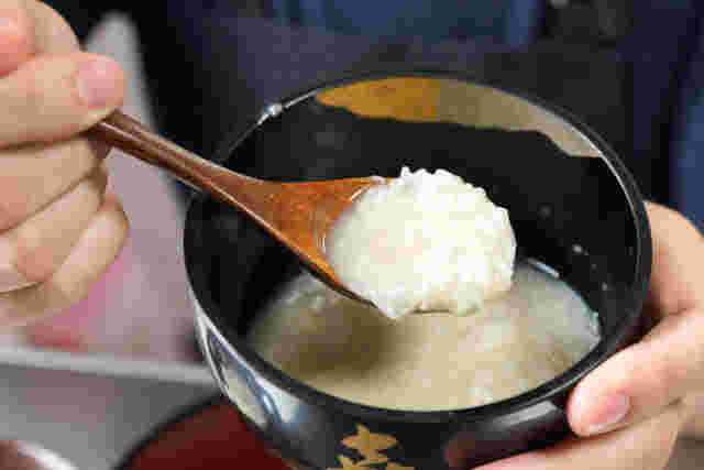 お椀に入った甘酒をスプーンですくっている様子