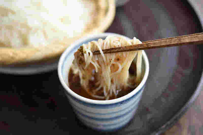 蕎麦にめんつゆをつけている様子