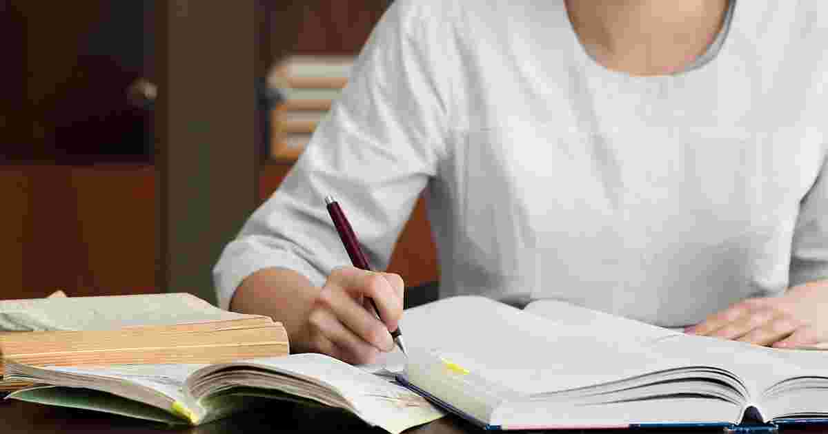 白いシャツの人が辞書を使って勉強している様子