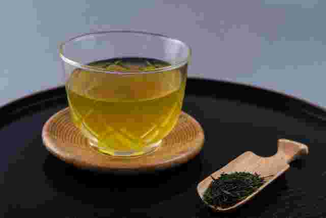 湯呑に入った緑茶と茶葉