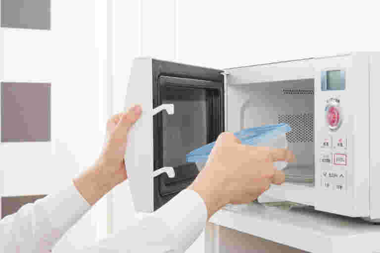 電子レンジからタッパーを取り出すイメージ