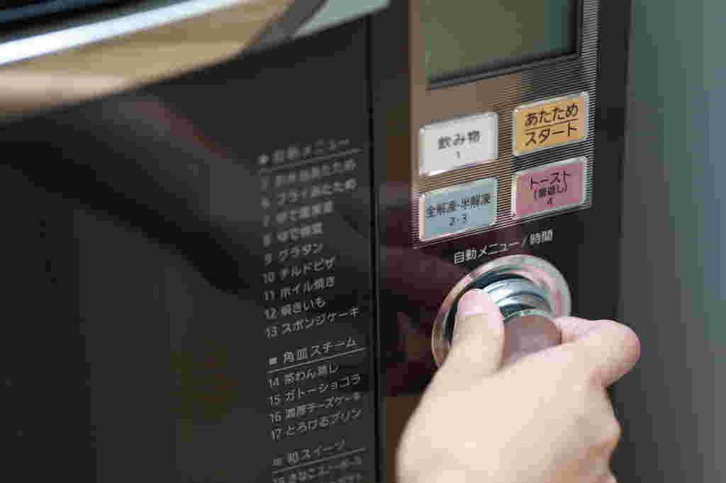 電子レンジのワット数を調整している手