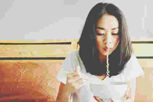 ラーメンを女性が食べている様子