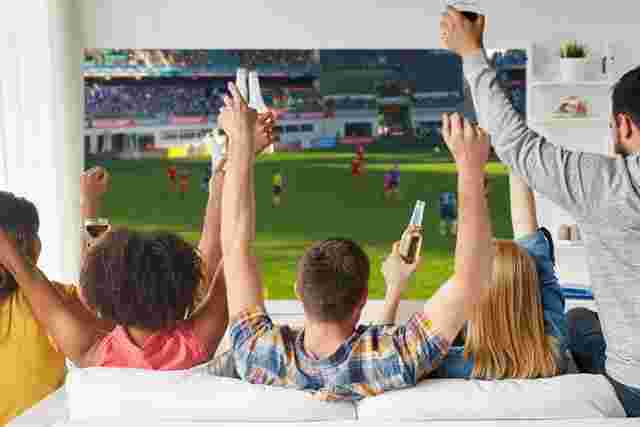 液晶テレビでサッカー観戦をする人々