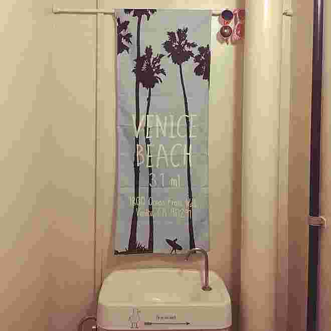 トイレに青地に植物のシルエットが浮かんだ細長いタペストリーが飾られている様子