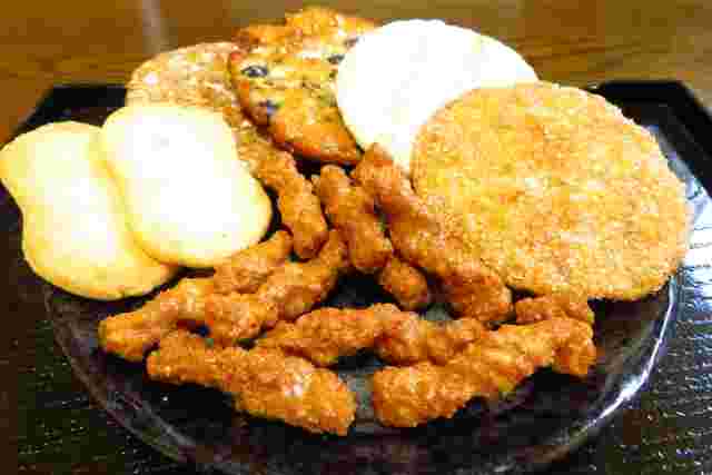 黒い器に乗った様々な味のせんべい