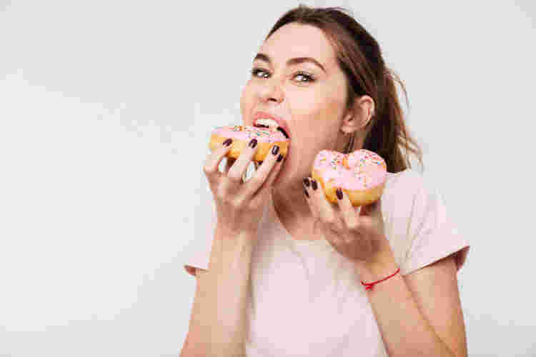 お尻周りが太る原因のドーナツを食べる女性