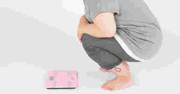 ダイエットの停滞期に体重計を前に躊躇する人