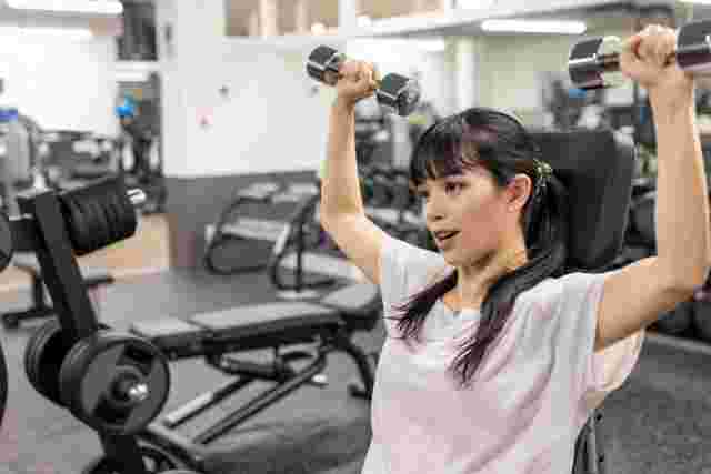 ダンベルで腕の筋トレをしている女性
