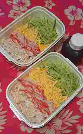 こんにゃく麺の上に、錦糸卵やきゅうり、かにかま、鶏ハムが乗っている