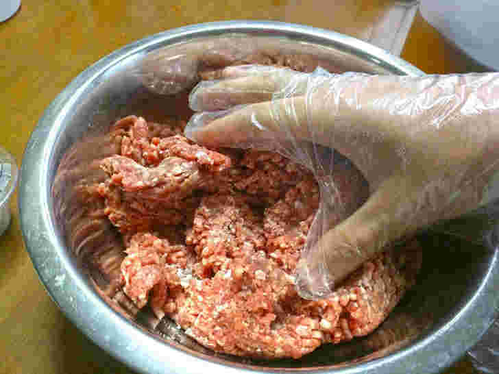 ボウルに豚ひき肉を入れてサラミを作っている様子