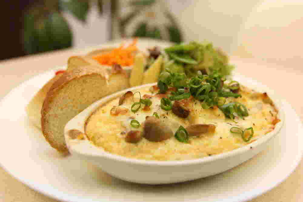 グラタン皿に盛られた自然薯と豆腐のグラタンとパン、キャロットラペ