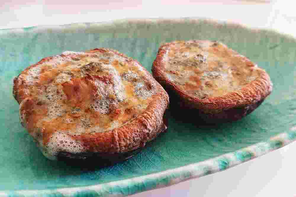 四角の淡い青のお皿に盛られた椎茸のブルーチーズ焼き