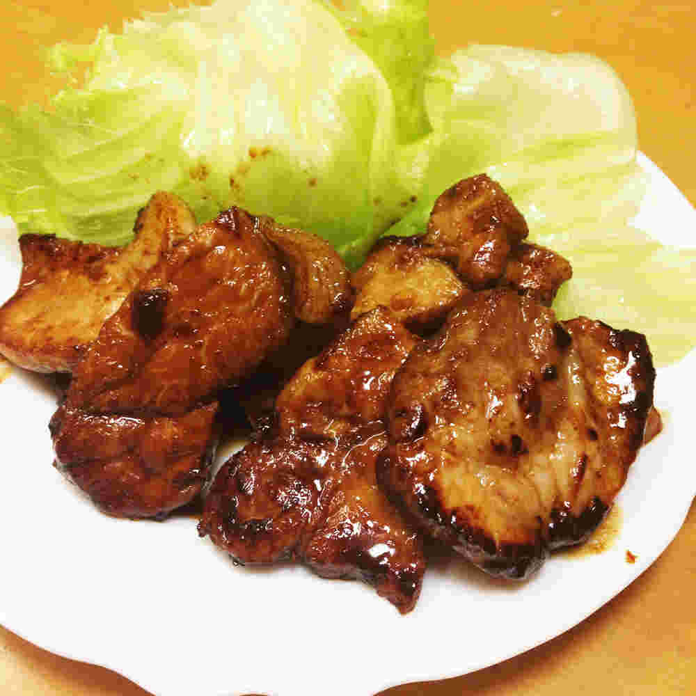 白いお皿に盛られた豚ロースの照り焼きオレンジピール風味