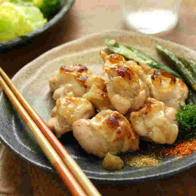 薬味の添えられた鶏肩肉の塩焼き