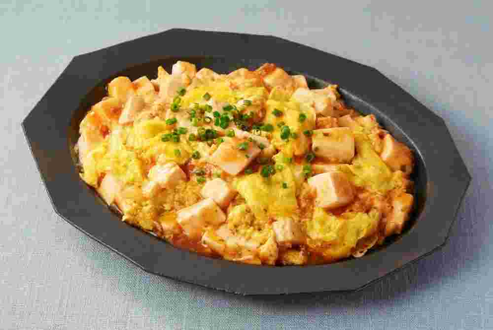 黒い皿に入っているふんわり卵と混ぜ合わさった麻婆豆腐