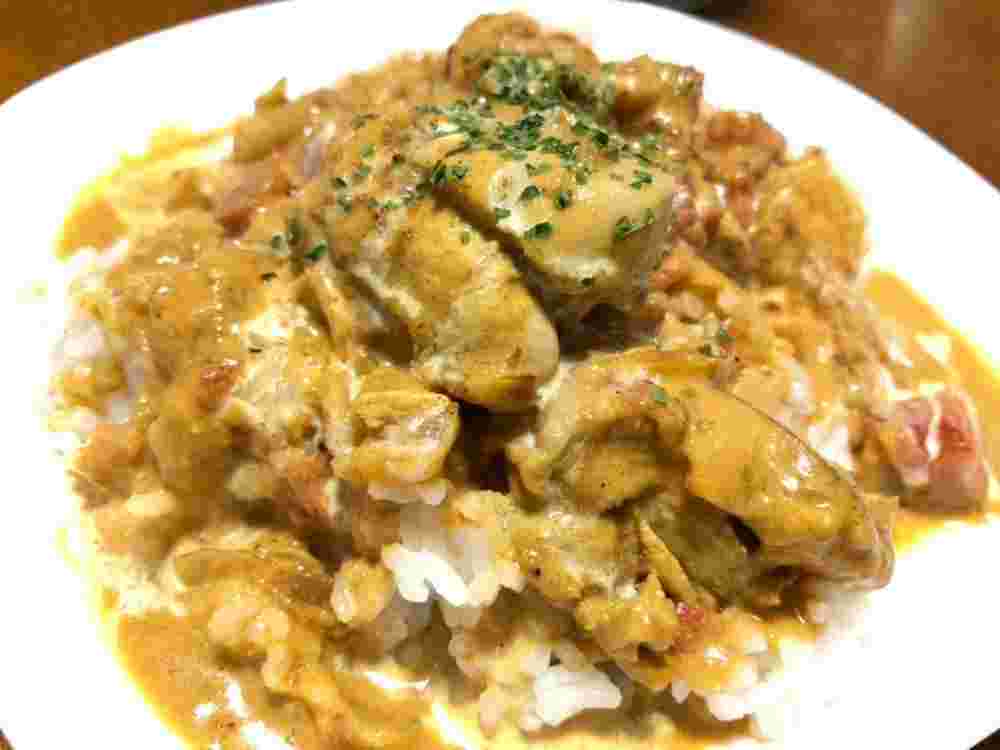 白い皿に盛られた黄色いまろやかなバターチキンカレー