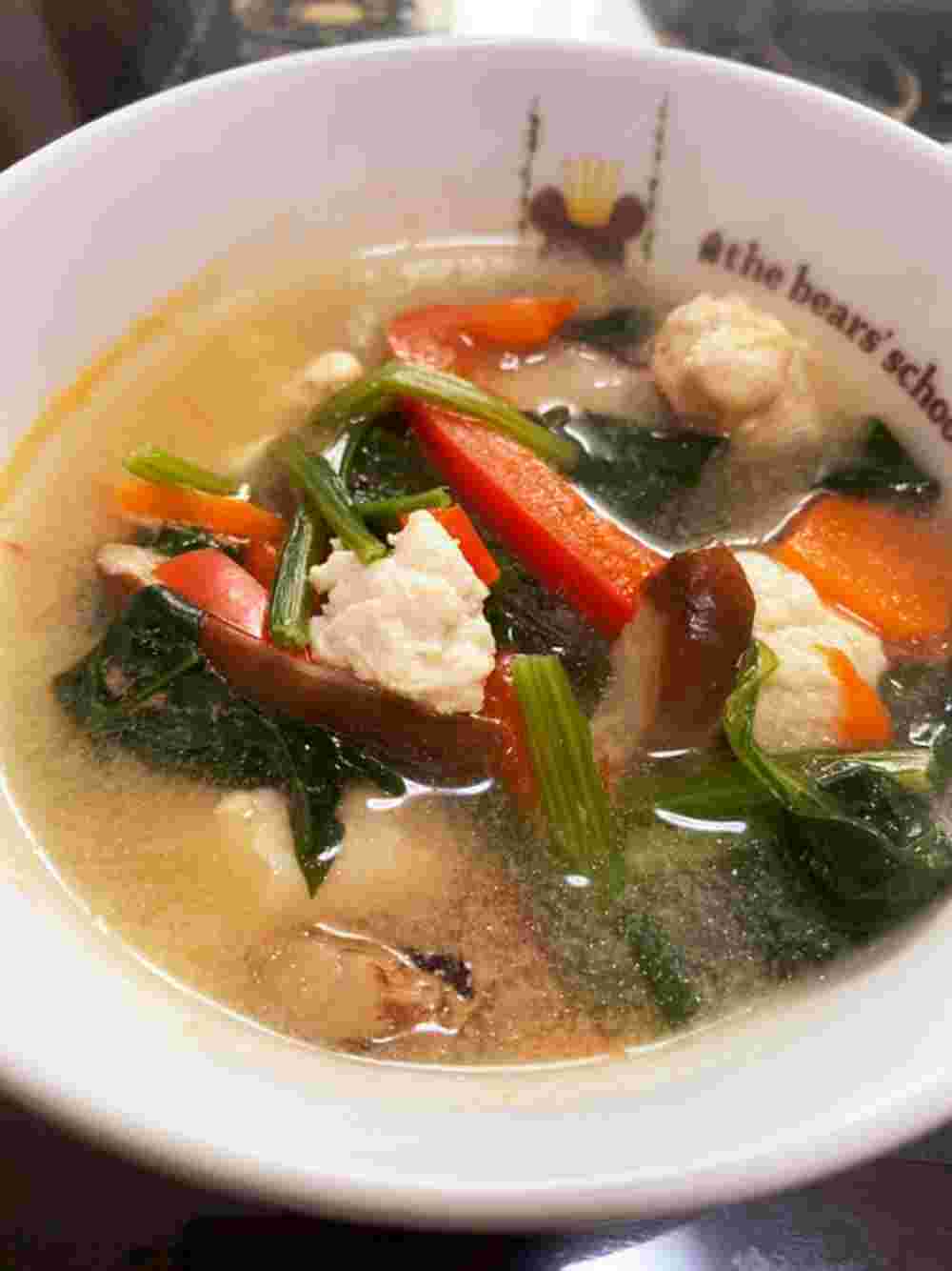 白い器に盛られた鶏団子とほうれん草の豆乳スープ
