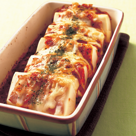 四角い器に盛られたベーコンも入っている豆腐のトマトチーズ焼き