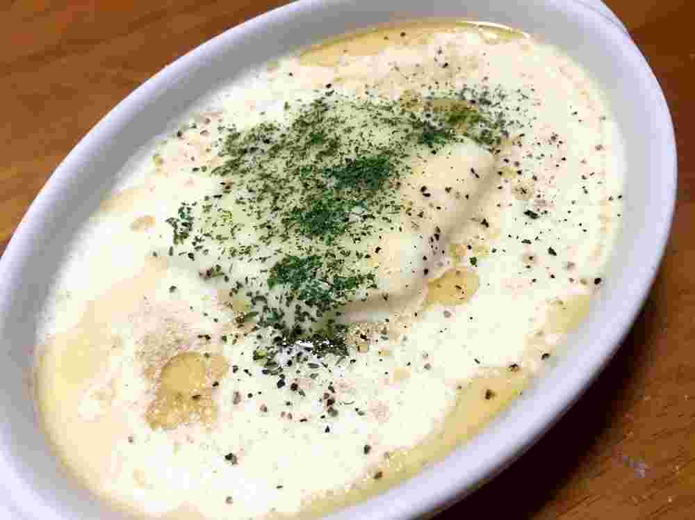 楕円形の白い器に盛られたベーコン入りの豆腐豆乳スープ
