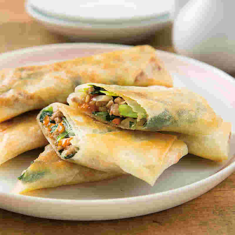 白い器に盛られた小松菜とひき肉の焼き春巻き