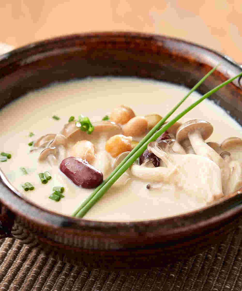 茶色の器に盛られた豆乳とキノコの和風スープ
