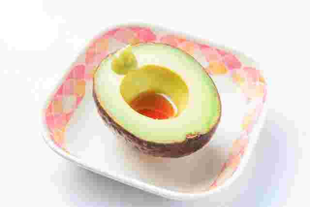 わさびと醤油がついている皿に乗ったアボカド