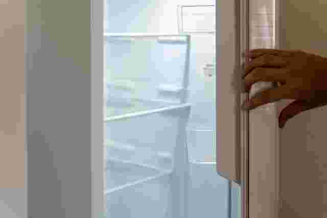 冷蔵庫の扉を開ける男性の手