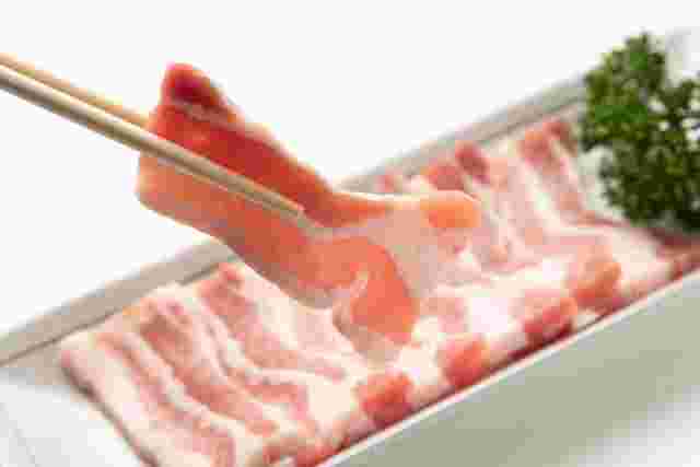 生の豚肉をつかんでいる箸