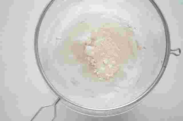 小麦粉をザルでこしている様子