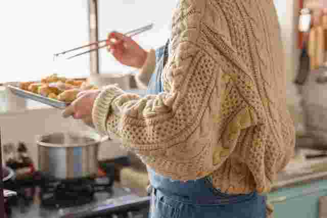茶色い食べ物を揚げる女性