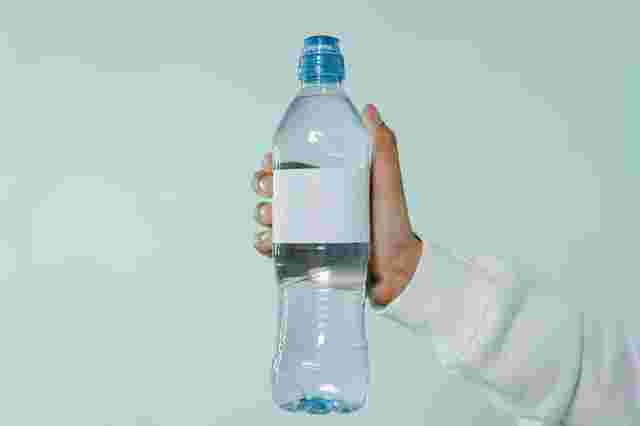水が入ったペットボトルを持っている手